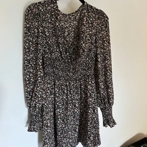 Klänning - Söt klänning med massa blommor. Det är en resår i midjan och en superfin v-ringning. Skriv för fler bilder💓
