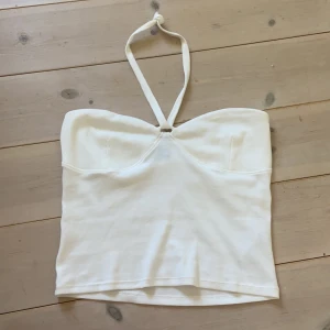 Halterneck topp vit - En vit halterneck topp från gina tricot. Aldrig använd. Strechig så passar både  XS S och M. 