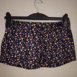Helt NYA och oanvända blommiga korta shorts, Strlk: 32 / XS, från Cubus. Material: Bomull. Har fickor fram och bak. Stängs med dragkedja och knapp. Helt felfria.