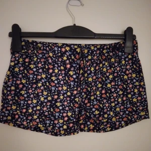 Helt NYA och oanvända blommiga korta shorts, Strlk: 32 / XS. Cubus. - Helt NYA och oanvända blommiga korta shorts, Strlk: 32 / XS, från Cubus. Material: Bomull. Har fickor fram och bak. Stängs med dragkedja och knapp. Helt felfria.
