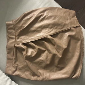 Läderkjol - Beige läderkjol, aldrig använd. Köparen står för frakt 