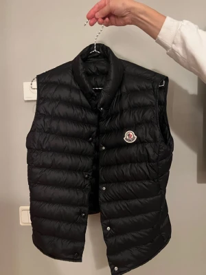 Moncler väst  - Säljer denna nu för den hänger bara i min garderob och vill bli av med den så fort som möjligt så jag kan sänka priset en del om de är så. Den har även en liten fläck vatten fläck inuti västen men inget mer med det . 