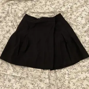 svart plisserad minikjol från asos! knappt använd tyvärr :-( spänns med knapp i midjan