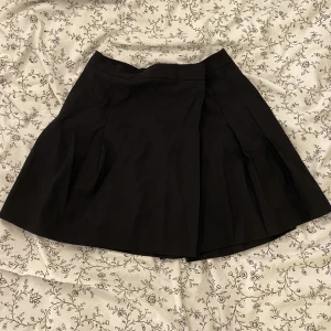 svart minikjol - svart plisserad minikjol från asos! knappt använd tyvärr :-( spänns med knapp i midjan