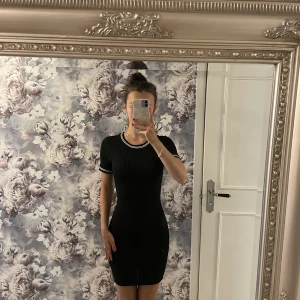 Svart ribbad klänning🖤 - Svart ribbad och kroppsnära klänning från H&M i bra skick. Sportiga detaljer vid halsringningen samt ärmarna. Klänningen är i storlek 32 (XS) och säljer den för 100kr.