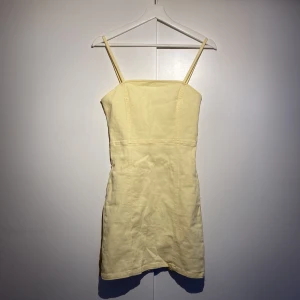 Gul klänning - Gul klänning från H&M, figurnära passform, ganska kort om man är som mig en lång tjej. Divided lappen är bortklippt.