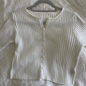 En vit tröja - En vit stretchig tröja med pärknappar i storlek S men samtisigt passar M väldigt bra. Jag har aldrig använt den då jag insåg att den inte passade min stil, tröjan är i nyskick. 