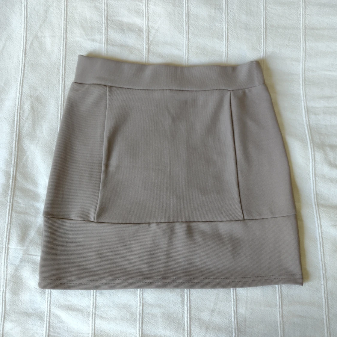 Beige figursydd och elastisk minikjol, storlek 36