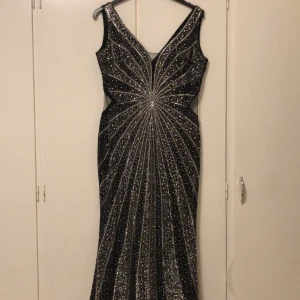 Svart Balklänning   - Supervacker lång skräddarsydd svart balklänning med olika typer av paljetter och stenar (se bild) mesh på sidorna (litet) som ger en superfin figursydd look. Perfekt för finare fest. fantastiskt skick, använd 1 gång