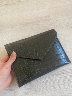 Kuvertväska - Grön crocomönstrad liten kuvertväska från Ichi. Oanvänd!