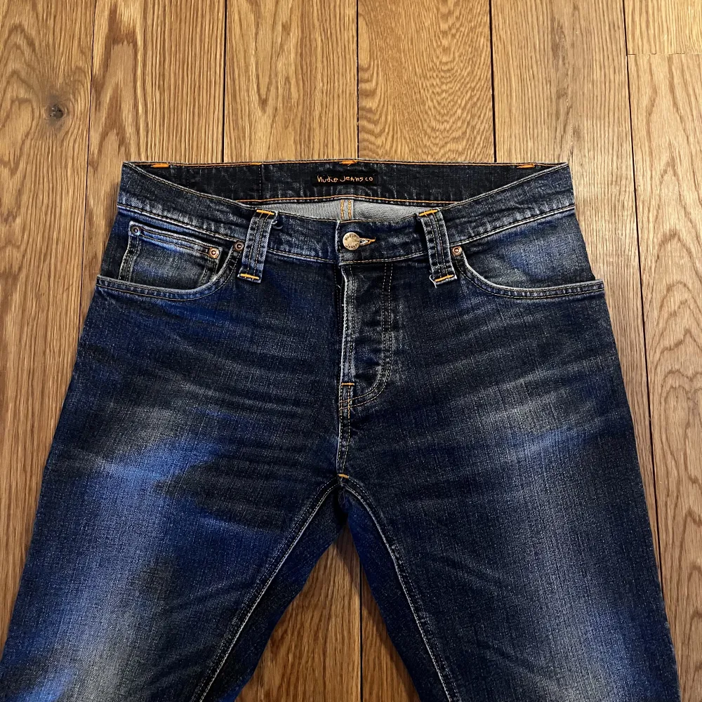Ett par feta tvättade mörkblå slim jeans: Grim Tim, från nudie som passar riktigt bra nu till vintern. De har använts varsamt och är i mycket gott skick. Storlek 31/32, modellen på bilden är 181 och väger 71kg. Nypris 1700 - vårt pris 545. Jeans & Byxor.