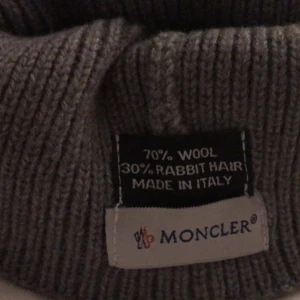 Moncler mössa. Dam, grå - Har aldrig använt den för de är en tjej mössa. Fick hem den i posten från ingenstans. Moncler mössor brukar gå runt 2000kr. 