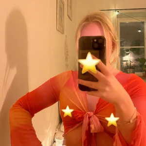 Blus/topp  - Supersöt rosa/orange topp i mesh med knyte fram. Aldrig använd! Väldigt stretchigt tyg. 