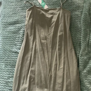 Klänning - Grön lång linne klänning som aldrig använts, lappen finns kvar