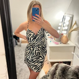 Festklänning - Snygg festklänning i zebra med korsade band på ryggen. Från h&m, strl 36.