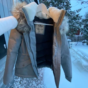 Vinterjacka - Grå vinterjacka med mjuk och varm krage och avtagbar päls på luvan. Nyskick 