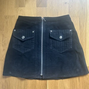 Kort svart kjol - Kort svart kjol med dragkedja och fickor. 