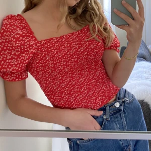 Blommig topp - Jätte söt röd blommig topp/blus från NA-KD. Använd max 3 gånger. Strl 34. Köpt för 249kr säljer för 70kr 