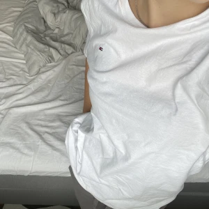 Tommy Hilfiger t-shirt - Säljer min brors vita Tommy Hilfiger t-shirt som knappt är använd. Den är i herr storlek men är en unisex tröja, alltså till för både tjejer och killar. Nypris ca 300kr. Pris går att diskuteras! Skriv privat för fler bilder! 😊
