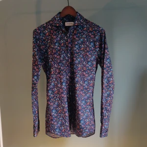Skjorta, John Henric  - Skjorta med mörkblå botten och blommigt mönster som passar både till fest/middagar och snyggare vardag. 
