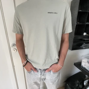 Axel Arigato T-shirt  - Säljer nu en riktigt snygg Axel Arigato T-shirt i storleken M! Den är i väldigt fint skick, nästintill oanvänd. Det är en tjej modell, men den passar lika bra till kille (kan va något liten). Tags och kvitto medföljer. Hör av dig vid fler frågor! 