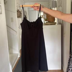 En svart klänning från Gina Tricot med knyt vid brösten i storlek S 