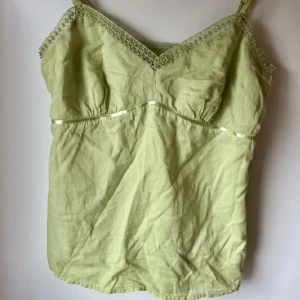 Grön topp - Supersöt grön topp från Gap! Justerbara band och en dragkedja vid sidan. Säljes pga för liten för mig💕