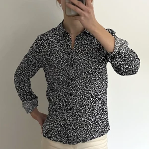 mörkblå blommig skjorta - mörkblå blommig skjorta/blus från monki i mjukt silkesliknande material. strlk xs men passar nog s oxå. 🤍