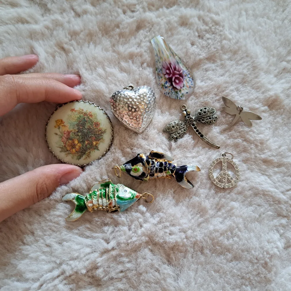 Lite olika berlocker som kan användas till smycken. 10kr/st (Den stora och lillatrollsländan är sålda och den stora runda med blommor jag håller i). Accessoarer.