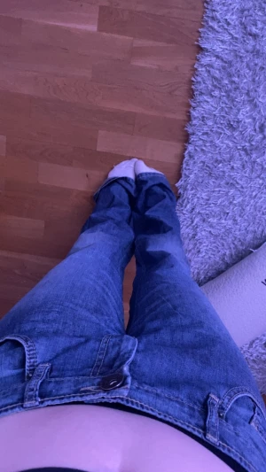 Lågmidjade flared jeans - Ett par blå lågmidjade jeans som är för stora för mig som man kan se på bilden’