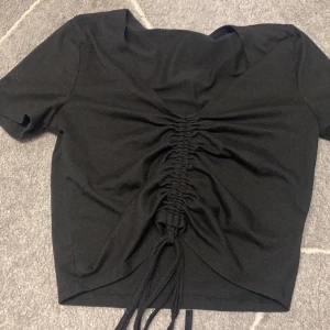 Topp - Säljer denna svarta topp från SHEIN. Defekter: söndrig på banden som man knyter men själv tycker jag inte det påverkar det så mycket . (Går att sy ihop). Funkar som xs. 