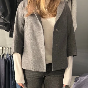 Trekvartsärmad jacka  - Supersnygg trekvartsärmad kappa. Den saknar storlek men skulle gissa på s-l beroende på vad man har på under. En sömm på insidan av jackan har börjat gå upp annars är den i superfint skick.