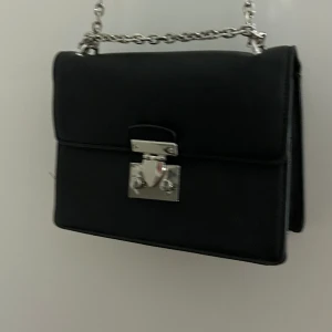 Svart axelremsväska  - En väska man kan ha med sig överallt får plats med väldigt mycket och är i bra skick