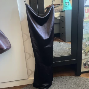 Svart klänning - Svart tight klänning med tunna band som är korsad i ryggen.  Aldrig använd! Köparen står för frakten. 