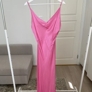 Slip Midiklänning  - Rosa slip midiklänning med slits på båda sidor. Med en draperad urringning.