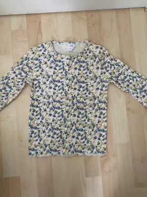 En blommig tröja i storlek 13-14år