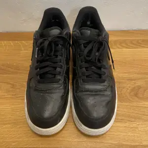 Svarta Nike Airforce 1’s Skicket som på bilderna, finns små hål i tyget på bakre delen av skorna som kan ses på första bilden. 