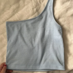 Topp - En one shoulder topp från Gina. Storlek S men passar allt från xs till M. 