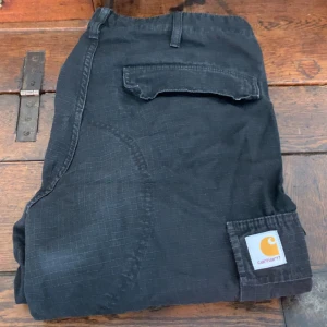 Carhartt WIP regular cargo pant black - Carhartt WIP cargopants Väldigt bra skick  Köpt i Köpenhamn på en carhartt butik  Storlek 34/32 Nypris:1499kr 