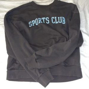 Sweatshirt  - En mörkgrå sweatshirt med tryck på bröstet. Inga skavanker 