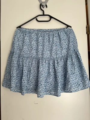 Blå blommig kjol - Blå kjol från Pamela X NA-KD kollektionen💗Endast använd en gång.