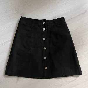 Kjol med knappar - Svart kort kjol med knappar framtill