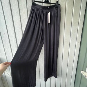 Utsvängda byxor  - Utsvängda, marinblå byxor med fickor. Aldrig använda och prislappen kvar 