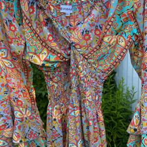 Multifärgad volang klänning med mönster och resår i midjan