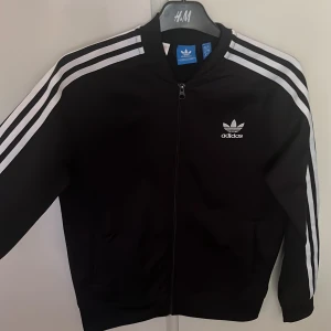 Adidas kofta  - En svart/vit adidas kofta från barnavdelningen men skulle säga att den passar en xs/s