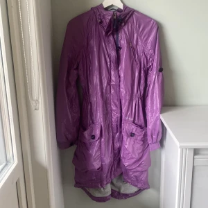 Peak performance kappa - En glansig snygg lila peak performance kappa med luva. Väldigt lite använd i storlek XS. 