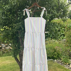 Randig klänning - Klänning i 100% bomull. Axelbanden knyter du på önskad längd.  Klänningen är sydd i överblivet tyg. Storlek S  Inga synliga tecken på användning 