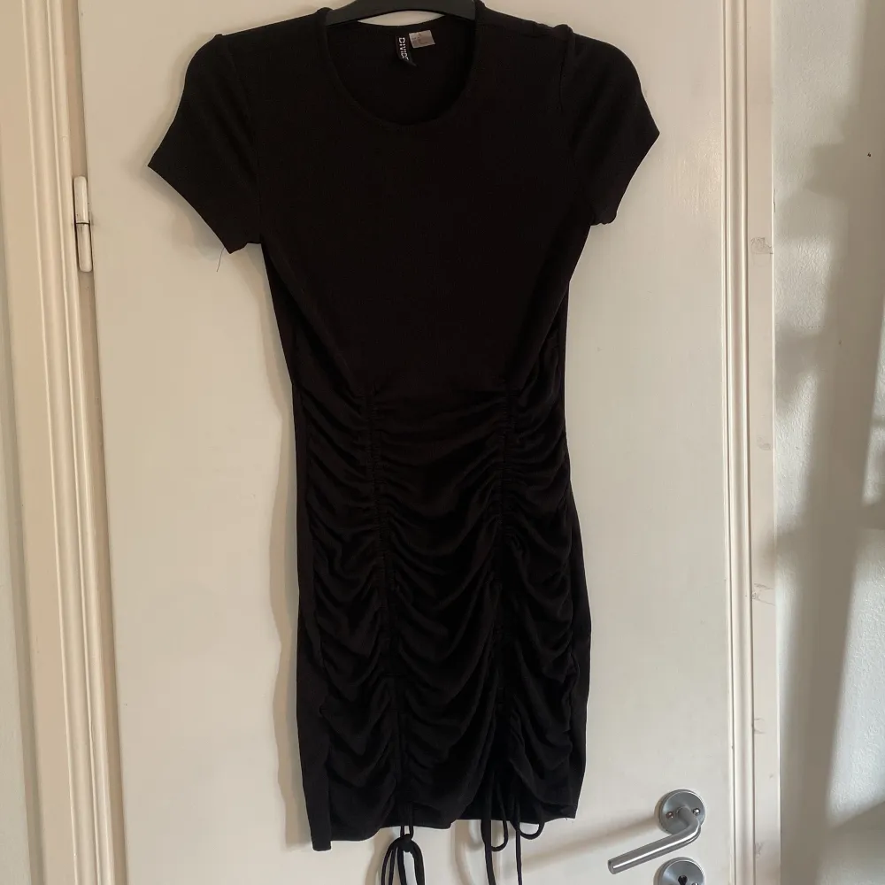 Svart klänning från H&M storlek Medium. Använd fåtal gånger men väldigt fin. Den har snörningar framtill på båda sidor. Säljes för att jag ej använder den längre. Klänningar.