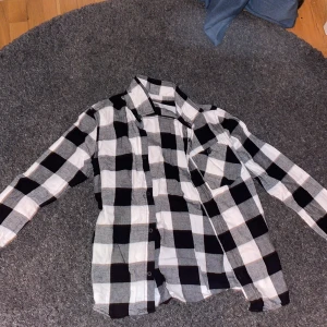 Skjorta - Riktigt snygg skjorta med svarta vita och gråa rutor på, nästan helt oanvänd.