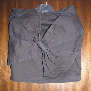 Kjol stor rosett i fram - Läcker kjol med stor rosett i fram. Modellen på bilden har 34/36 i kläder och är ca 168 cm lång. Fint skick.